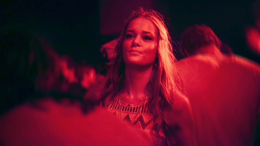 Portrait in red light on a crowded dance floor